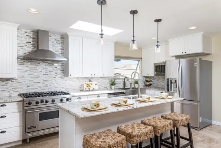 Large kitchen with a range hood, stone island and woven counter stools