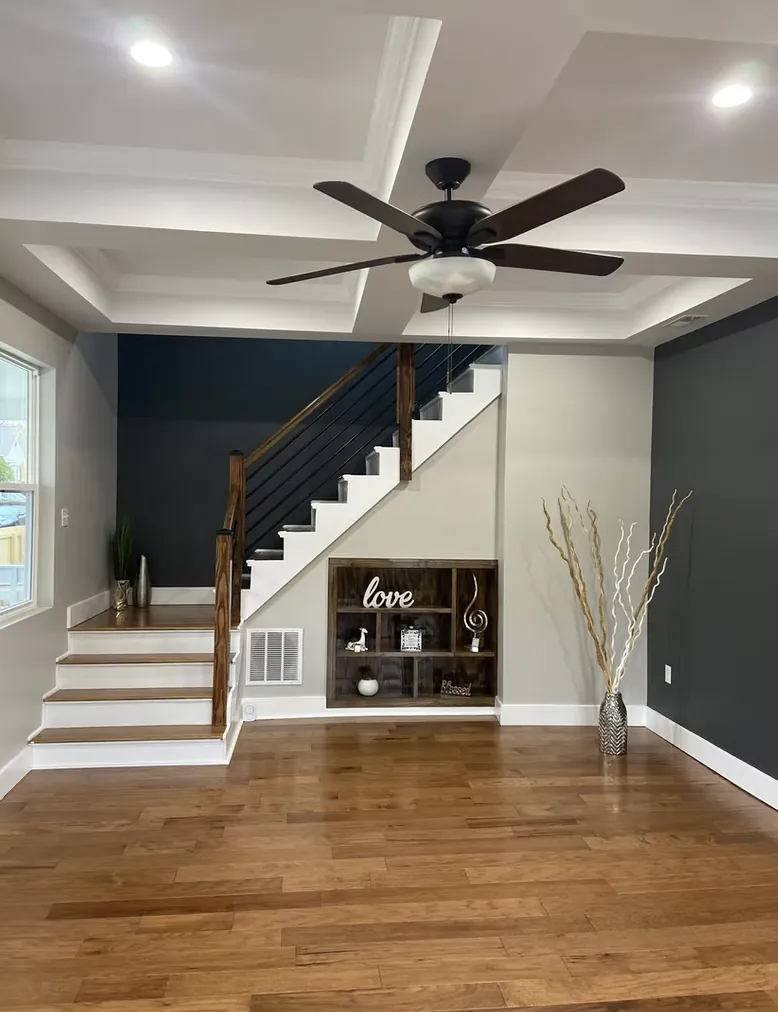 Open living room with a staircase, ceiling fan and hardwood floor