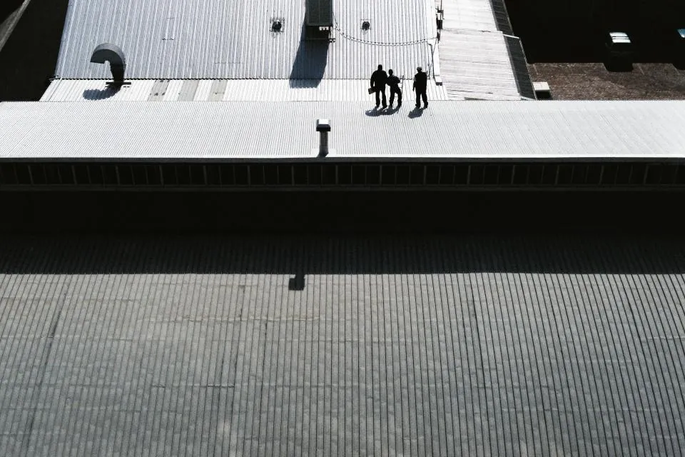Workers walking across a large metal roof